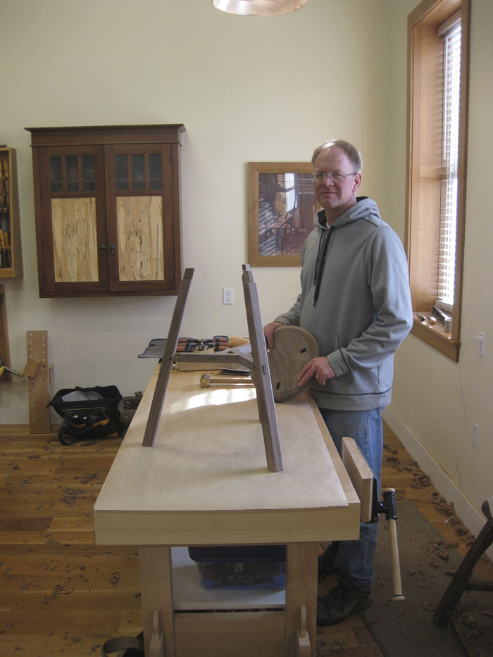 Man woodworking at bench in sunlit shop